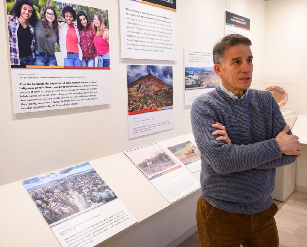 LACC Deputy Director Manuel Román-Lacayo standing in the permanent exhibit gallery featuring educational displays about the history and geography of Latin America.