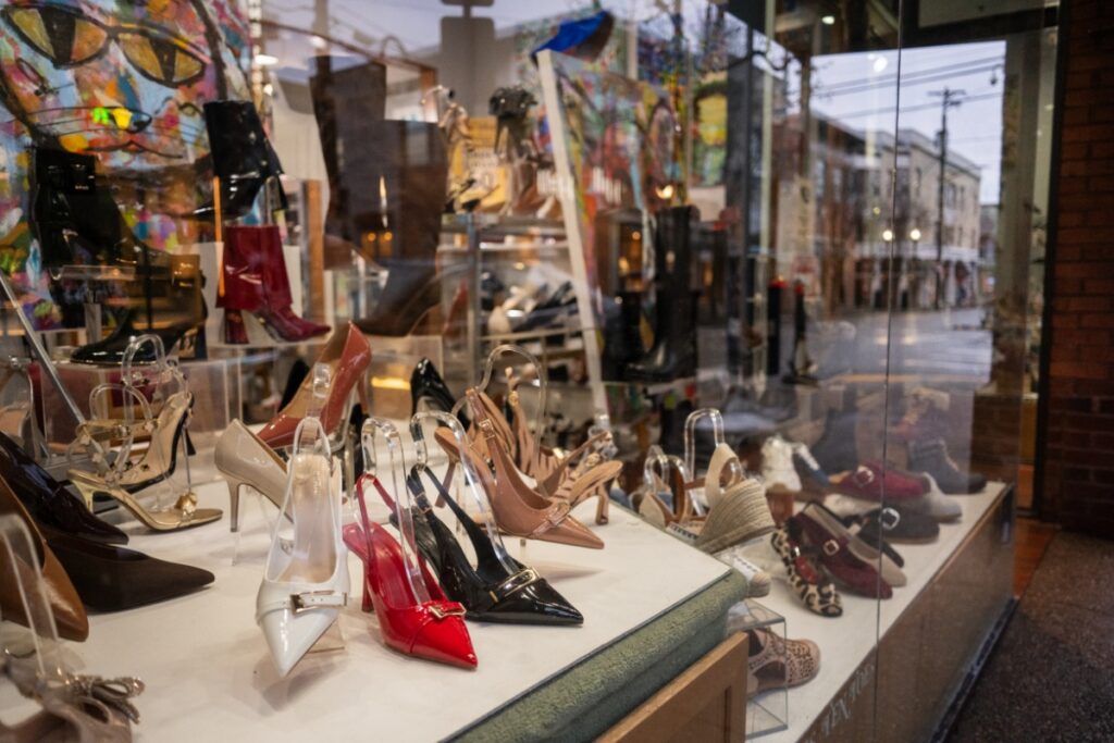 A storefront window display at Ten Toes on Walnut Street in Shadyside, showcasing a variety of elegant women's high heels, pumps, and designer footwear in neutral and vibrant colors.