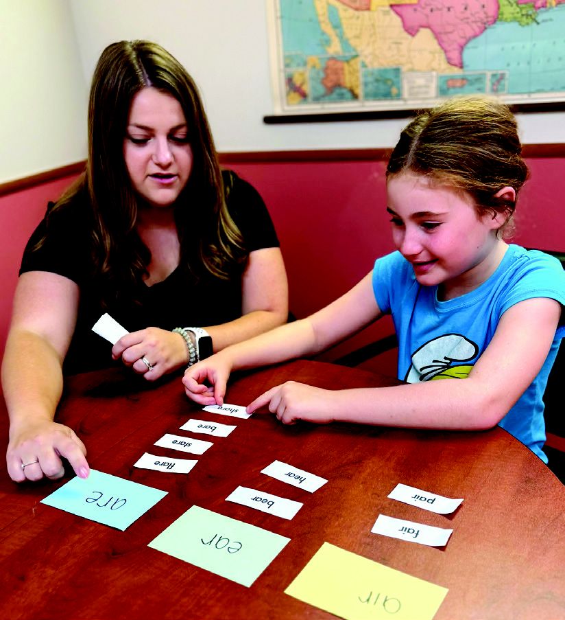 A specialized reading tutor at Pittsburgh Tutor using word cards and phonics activities to build foundational skills with an elementary student.