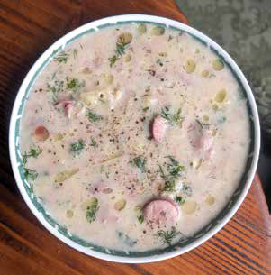 A creamy, comforting bowl of homemade potato soup topped with sliced kielbasa sausage, fresh dill, and cracked black pepper.