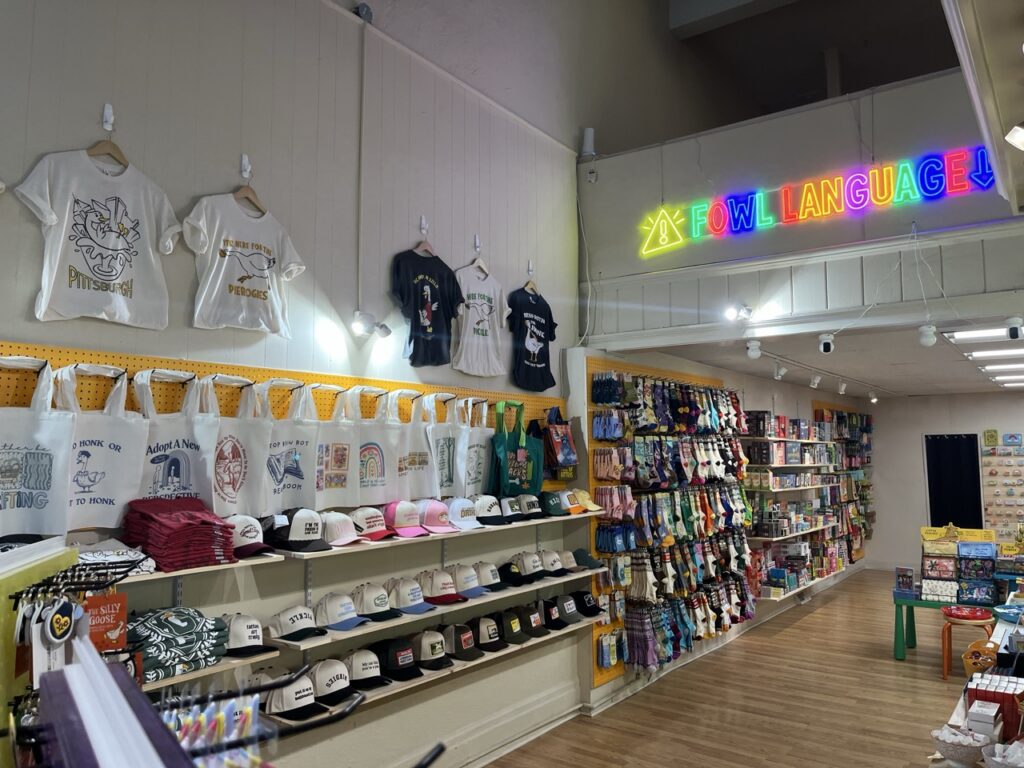 A wall of shirts and tote bags and socks at The Silly Goose. 