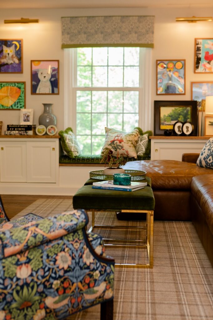 Cozy living room interior featuring a custom window seat, William Morris accent chair, and gallery art wall by madDesigns.