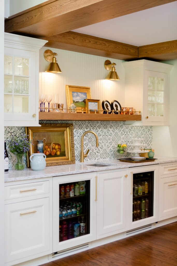 Luxury wet bar with marble countertops, pattern tile backsplash, gold fixtures, and under-counter beverage coolers.