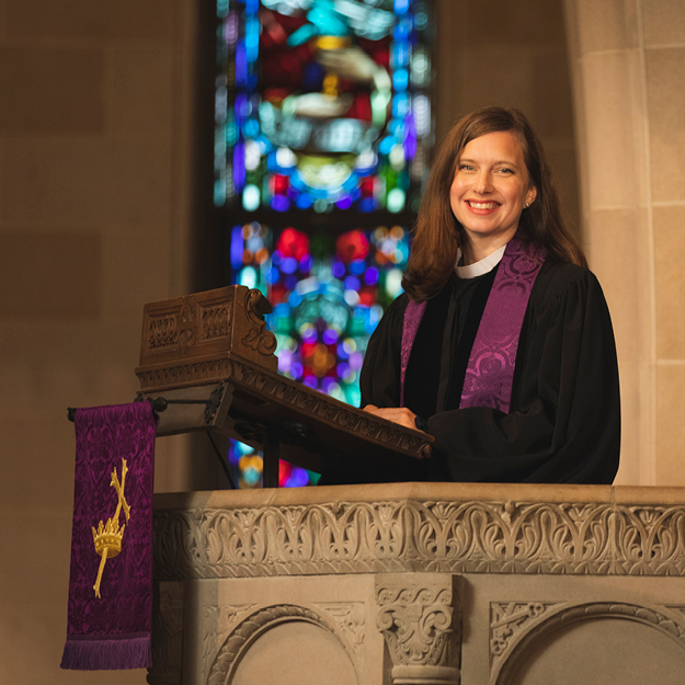 Rev. Austin Shelley smiling at the pulpit in front of a stained glass window at Shadyside Presbyterian Church.