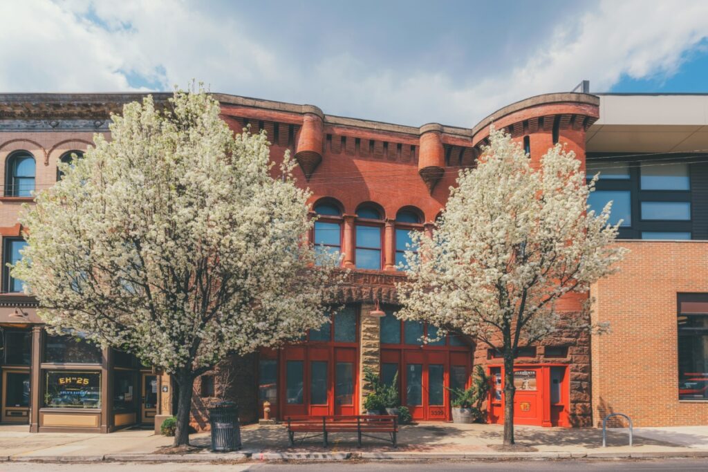 The historic Engine House 25 building framed by blooming white spring trees on Butler Street in Lawrenceville.