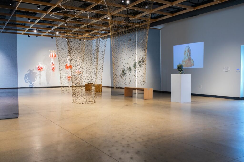 The spacious interior of the Contemporary Craft art gallery in Pittsburgh, showcasing multimedia installations and hanging textiles.