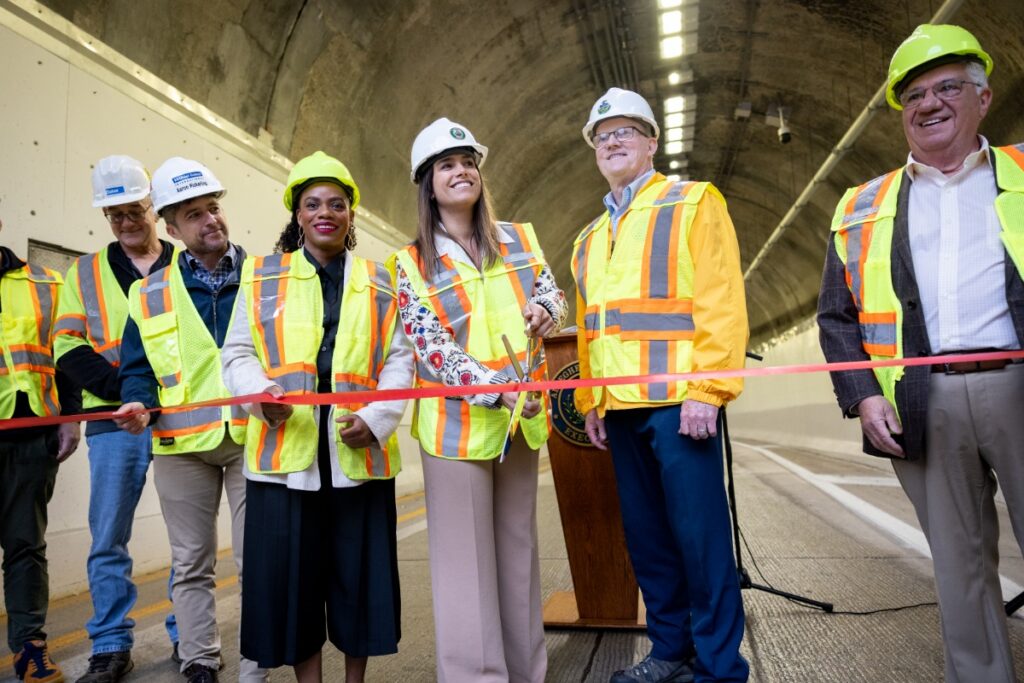 County Executive Sara Innamorato cutting the red ribbon at the Armstrong Tunnel reopening ribbon-cutting ceremony in Pittsburgh.