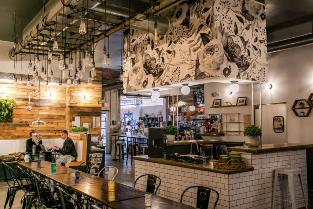 Interior view of the spacious dining room, industrial ceiling lights, and coffee bar counter at Ineffable Cà Phê.