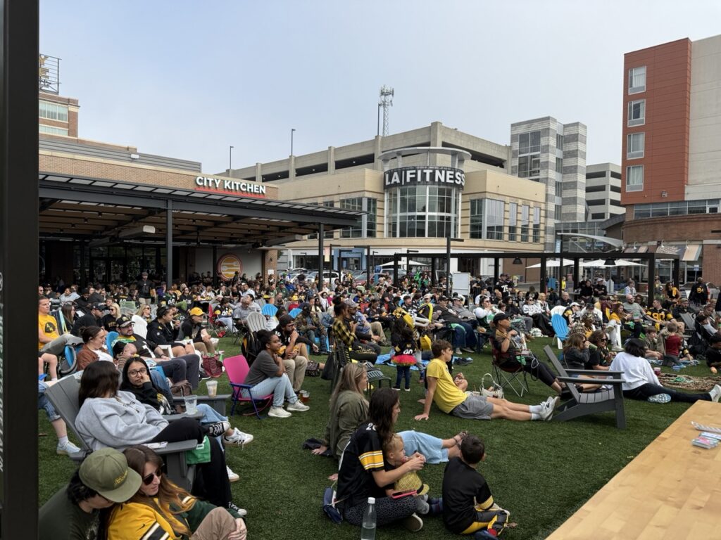 A bunch of people sit on the lawn at Bakery Square.