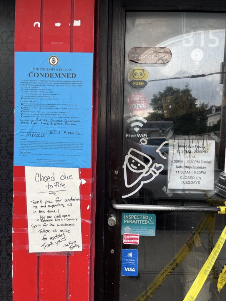 The door to Fujiya Ramen with signs about the building being closed and condemned.