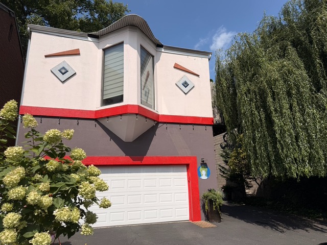 The outside of a white and grey house which windows and garage look like a face.