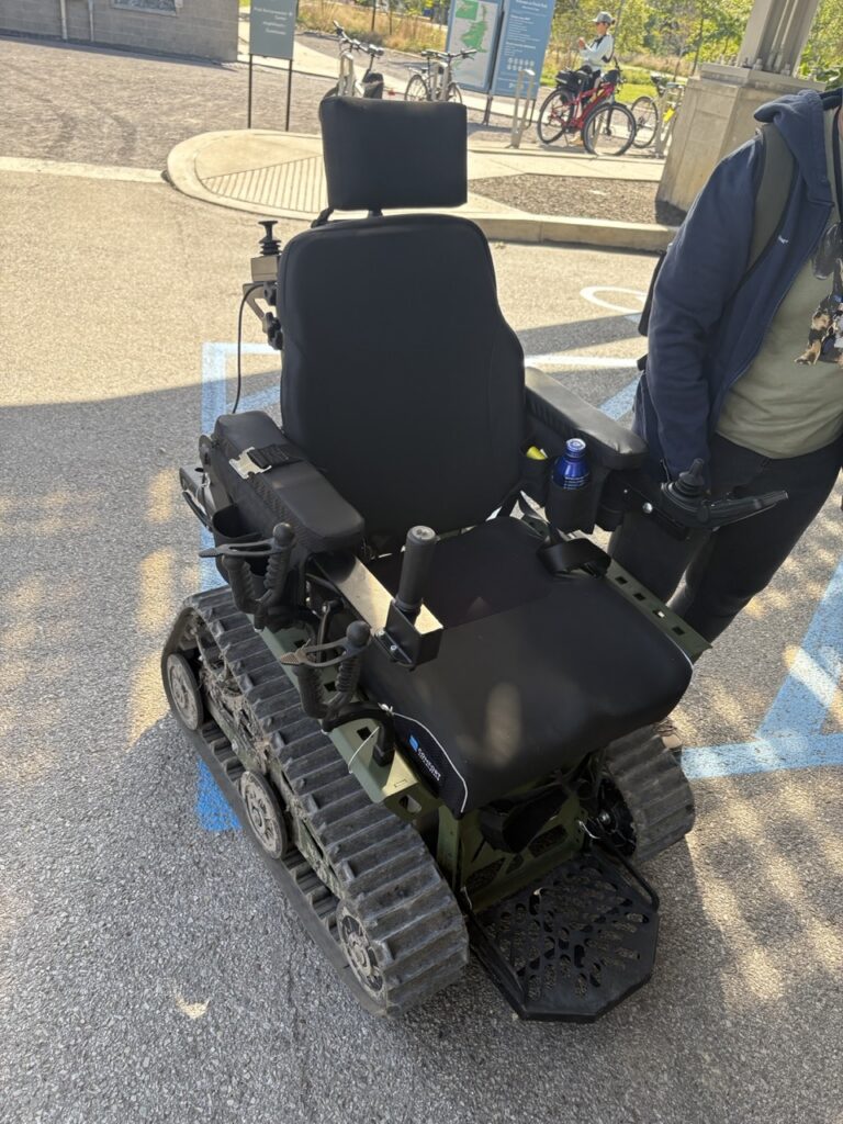 A trackchair sits in a parking lot in black.